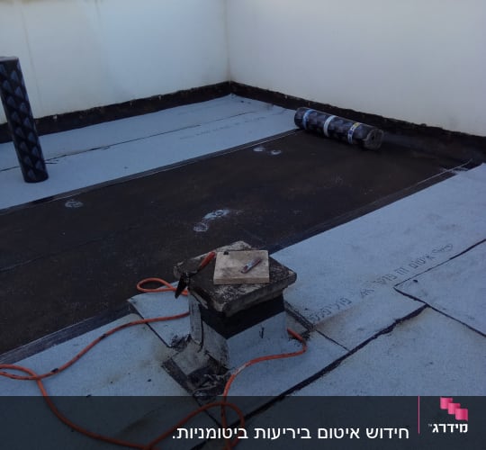 גג עם יריעות איטום, כבל חשמלי וכלי עבודה